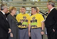 Bundeskanzlerin Angela Merkel im Gespräch mit den Opel-Mitarbeitern Jürgen Tyranowski (links) und Norbert Kirschner, daneben Opel-Chef Hans Demant (links) und Produktionsvorstand Reinald Hoben. Foto: Auto-Reporter/Opel